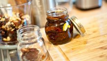 Rezept Foto von den eingelegten getrockneten Tomaten. Das Foto zeigt ein Einweckglas voller getrockneter Tomaten und eine Flasch Olivenöl.