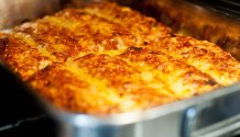 Rezept Foto von Enchilladas. Das Foto zeigt einen Blick in den Backofen. Die Enchilladas sind in der Edelstahlform fast fertig gebacken. Gold gelb färbt sich der Käse. Gleich ist es soweit.