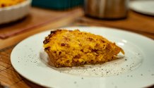 Rezept Foto der Kürbisquiche. Das Foto zeigt die noch dampfende Kürbisquiche. Angerichtet auf einem runden Teller, garniert mit frischem Pfeffer aus der Mühle.