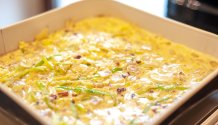 Rezept Foto des Lauchzwiebelkuchens. Das Foto zeigt die noch nicht gebackene Lauchzwiebelkuchen Masse in einer Kuchenspringform. Gleich kommt Sie in den Ofen.