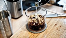 Rezept Foto vom Roten Pesto. Das Foto zeigt wie Katharina gerade Öl in den Mixer gibt, damit anschließend alle Zutaten zum Roten Pesto werden.
