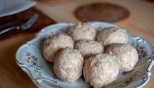 Die Semmelknödel sind auf einem alten bayerischen Teller angerichtet und dampfen noch, da sie gerade aus dem Wasserbad kommen.