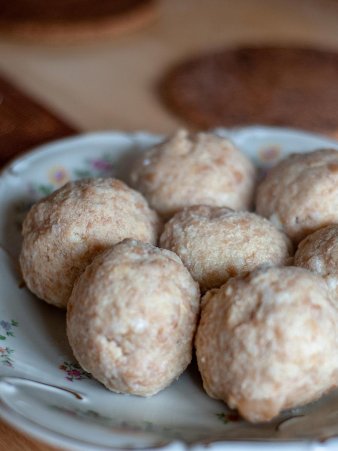 Die Semmelknödel sind auf einem alten bayerischen Teller angerichtet und dampfen noch, da sie gerade aus dem Wasserbad kommen.