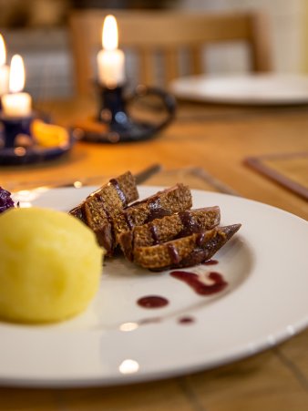 Rezept Foto Barbarbie Entenbrust angerichtet auf einem weihnachtlich dekoriertem Teller.