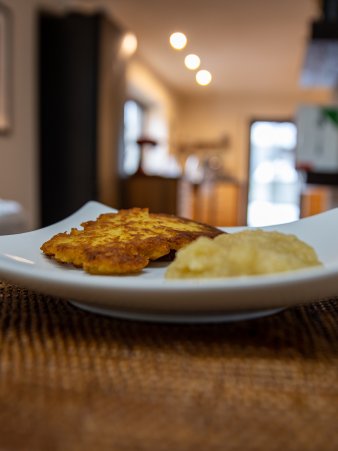 Rezept Foto vom Bayerischen Dotsch auch Reiberdatischi genannt. Goldbraun gebraten liegt er mit einem Klecks Apfelmuß angerichtet auf einem Teller.