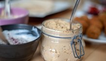 Rezept Foto vom Hummus auf dem schmankerl.space. Der Hummus ist in ein Einweckglas gefüllt und steht auf dem Essenstisch bereit für den Falaffel Wrap. Mega lecker!