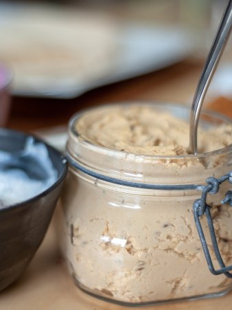 Rezept Foto vom Hummus auf dem schmankerl.space. Der Hummus ist in ein Einweckglas gefüllt und steht auf dem Essenstisch bereit für den Falaffel Wrap. Mega lecker!