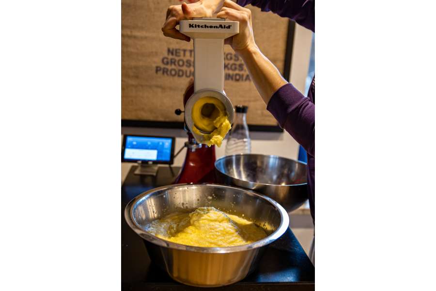 Rezept Foto Kartoffelpuffer. Katharina reibt die Kartoffeln für den Puffer mit einer Kartoffelreibe in der Küchemaschine.