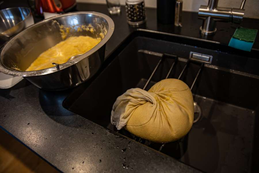 Manfred drückt die Kartoffelmasse durch ein Kloßsäckchen, damit das Stärkewasser entweicht.