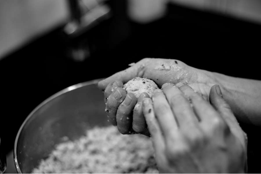 Rezept Foto Falaffel. Katharina rollt gerade die Teiglinge mit den Händen. Schwarz Weiss Foto.