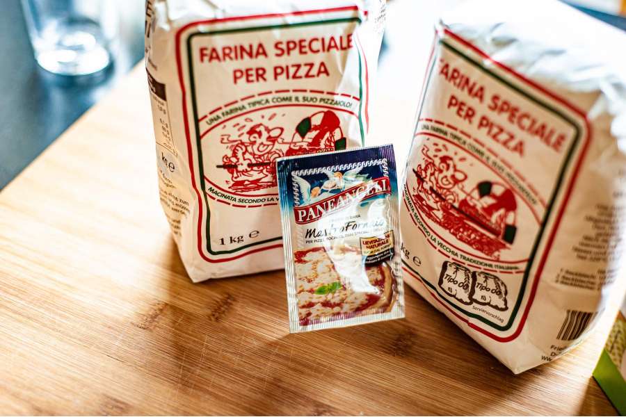 Rezept Foto Holzofen Pizza Komplettanleitung. Verschiedene Mehle und eine italienische Bierhefe stehen auf dem Holzbrett bereit für das Pizzabacken bzw. den Teig.