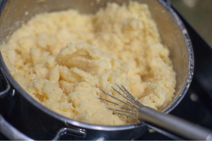 Mama Siglinde hat gerade mit einem Schneebesen die durchgedrückten Kartoffeln mit etwas Milch verrührt. Es entsteht ein sämiger Kartroffelbrei.