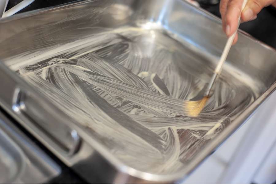Rezept Foto Oberpfälzer Milchrahm Apfelstrudel. Katharina bepinselt eine Backform mit der zerlassenen Butter.