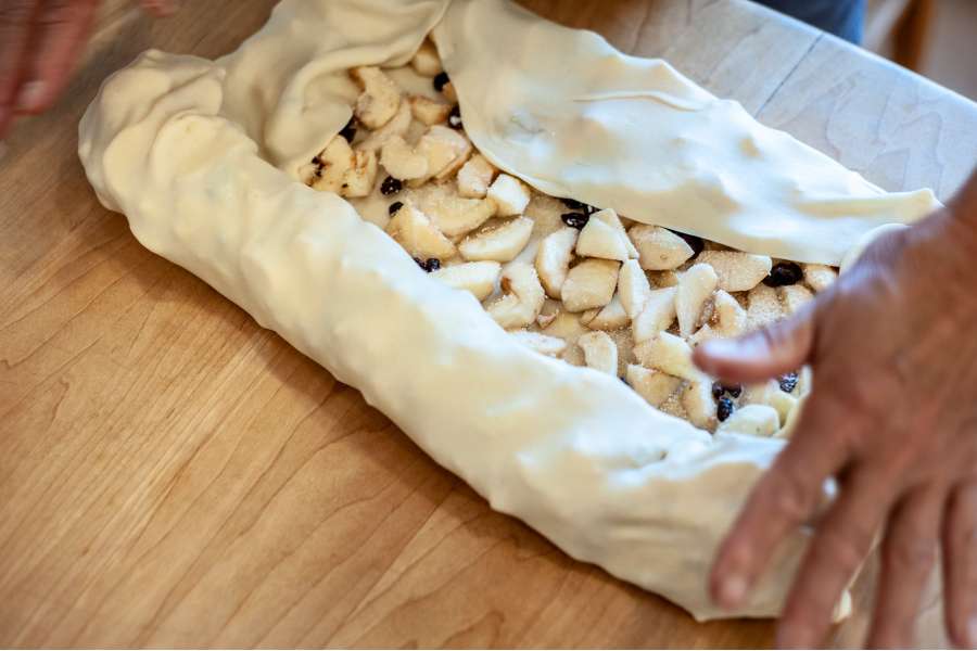 Rezept Foto Oberpfälzer Milchrahm Apfelstrudel. Fast geschafft, der Teig ist beinahe zusammengerollt.