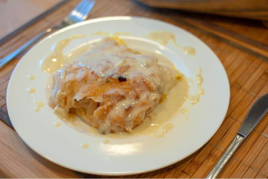 Rezept Foto Oberpfälzer Milchrahm Apfelstrudel. Der Oberpfälzer Milchrahmstrudel angerichtet auf einem china bone Teller mit Vanillesoße.