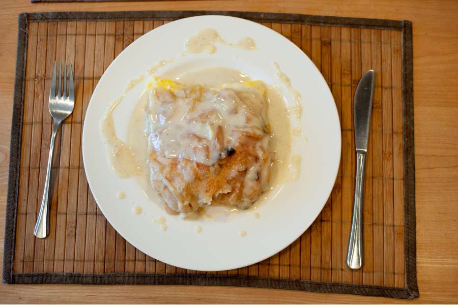 Rezept Foto Oberpfälzer Milchrahm Apfelstrudel. Draufsicht: Oberpfälzer Milchrahmstrudel angerichtet auf einem china bone Teller mit Vanillesoße.
