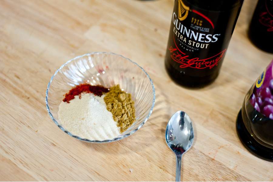 Rezept Foto BBQ Barbecue Bier Sauce. Die Gewürzmischung in einem kleinen Schälchen neben einem Schwarzbier gestellt.