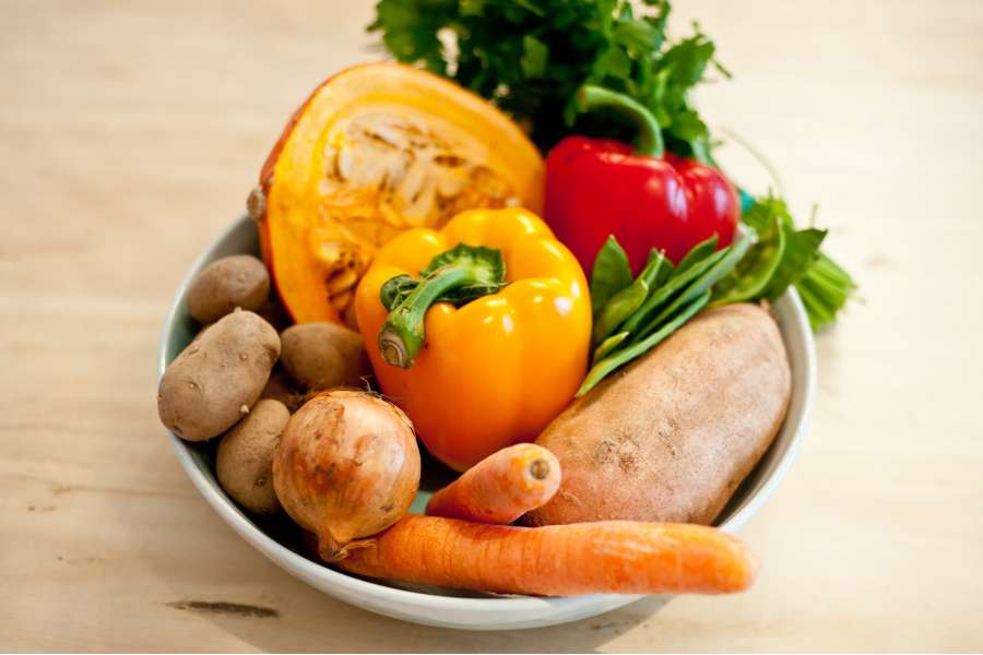 Rezept Foto Buntes Garten Ofengemüse. Das frische Gartengemüse liegt in einer schönen handgetöpferten Schale bereit geschält und geschnibbelt zu werden.