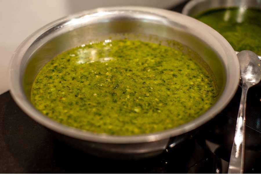 Rezept Foto Kräuter und Garten Pesto. Ein Teil des Pestos wurde bereits mit dem Pürierstab fein gemacht und zu einer glatten Masse verarbeitet.