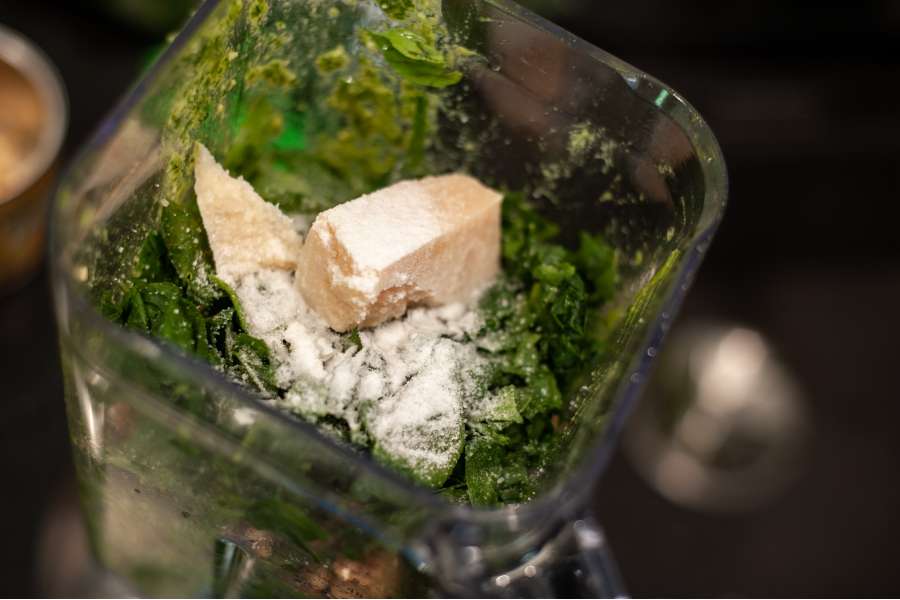 Rezept Foto Kräuter und Garten Pesto. Ansicht des Blenders mit den Kräutern, dem Knoblauch und den Gewürzen.