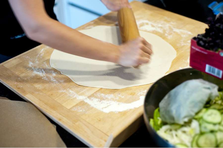 Rezept Foto Grillpizza und Ofenpizza Italien. Katharina rollt den Teig zum Schluss auf dem Schneidebrett aus.