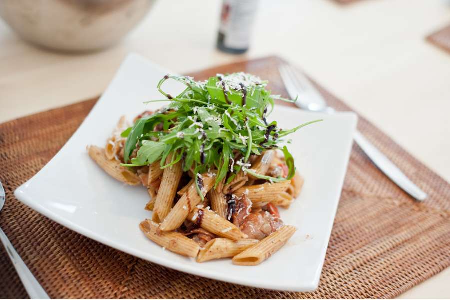 Rezept Foto Italienischer Nudelsalat. Nahaufnahme des Nudelsalats, es sind sehr schön die verschiedenen Zuataten wie Parmaschinken, Pinienkerne und die Balsamico Creme zu sehen.