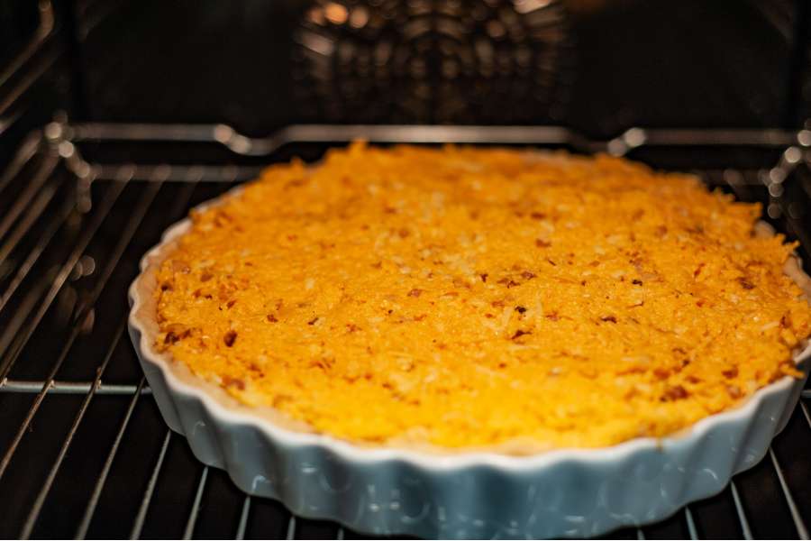 Rezept Foto Kürbis Quiche selber machen. Einblick in den Ofen, in dem die noch rohe Quiche liegt.