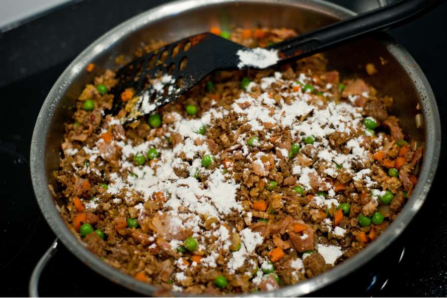 Rezept Foto Lasagne selber machen. Die Hackfleischmasse wird am Schluß noch in der Pfanne mit Mehl bestäubt, damit die Masse später sämiger wird und nicht zu sehr wassert.