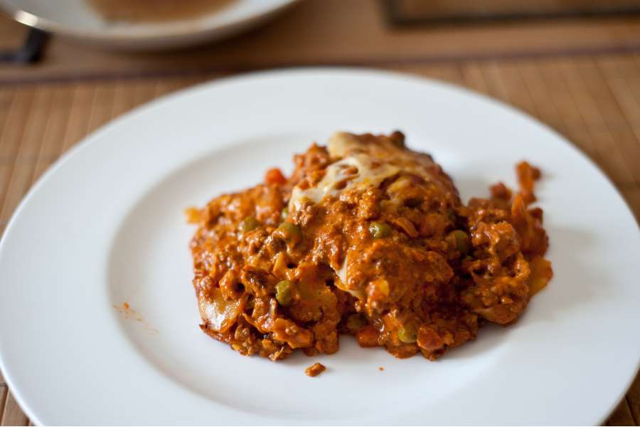Rezept Foto Lasagne selber machen. Detailaufnahme der Lasagne auf einem runden china bone Teller.