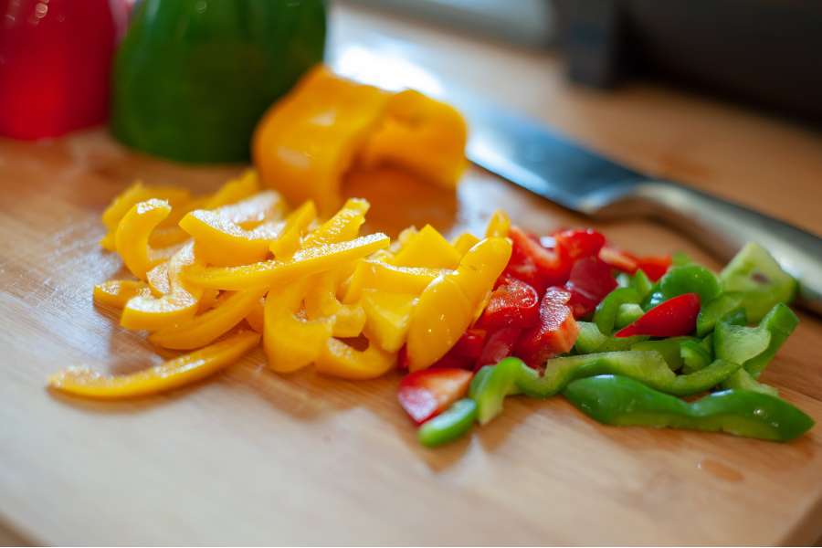 Rezept Foto Mexikansiche Grill Fajitas. Auf dem Schneidebrett werden die Paprikas für die Fajita Füllung vorbereitet bzw. kleingeschnitten.