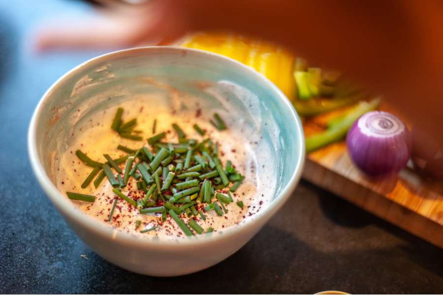 Rezept Foto Mexikansiche Grill Fajitas. Der Dip für die Fajitas ist in einem Schälchen angerichtet, garniert mit frischem Schnittlauch aus dem Garten.