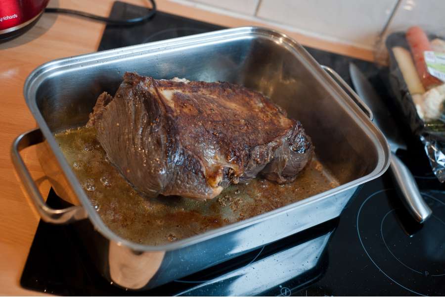 Rezept Foto Sauerbraten mit Serviettenknödel. Der Sauerbraten wird in einem Bräter mit Butterschmalz rundherum scharf angebraten. Die Röststoffe werden eine Grundlange für die schmackhafte Soße.