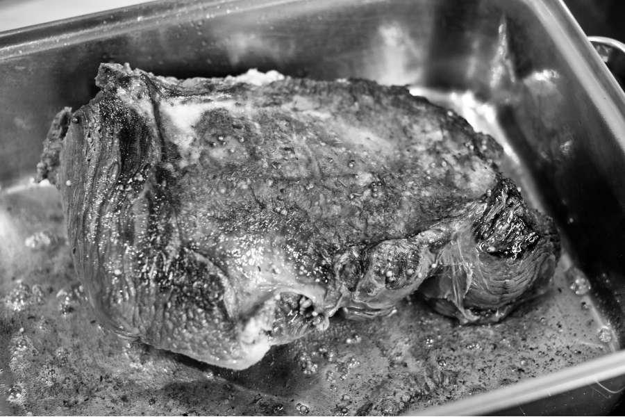 Rezept Foto Sauerbraten mit Serviettenknödel. Schwarz Weiss Foto des Sauerbratens im Bräter. Die Kruste des Bratens nimmt langsam Form an.
