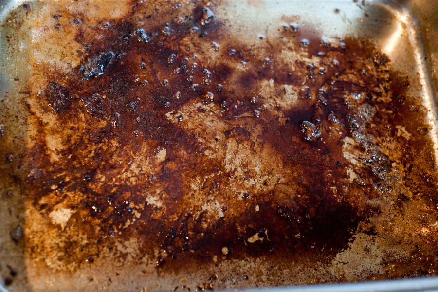 Rezept Foto Sauerbraten mit Serviettenknödel. Ansicht des Bräterbodens nach dem Entfernen des Tafelspitzs. Der Boden hat viel Röststoffe angesetzt und wird gleich mit Brühe abgelöscht.
