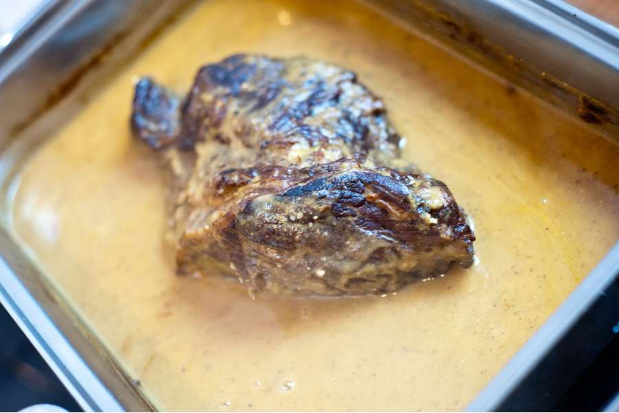Rezept Foto Sauerbraten mit Serviettenknödel. Nachdem die Soße gemacht wurde kommt diese zusammen mit dem Sauerbraten zurück in den Bräter. Der Braten ruht in der Soße und nimmt den Geschmack bereits auf.