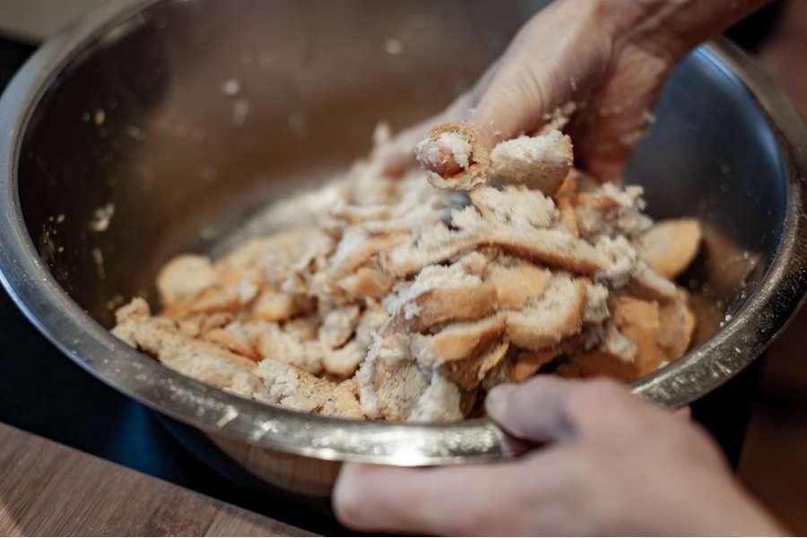Rezept Foto selber gemachte Semmelknödel. Die übergossenen Semmeln mit der Hand vermengen.