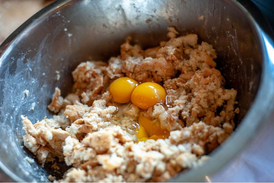 Rezept Foto selber gemachte Semmelknödel. Die Eier zur vermengten Semmelknödel Masse geben.