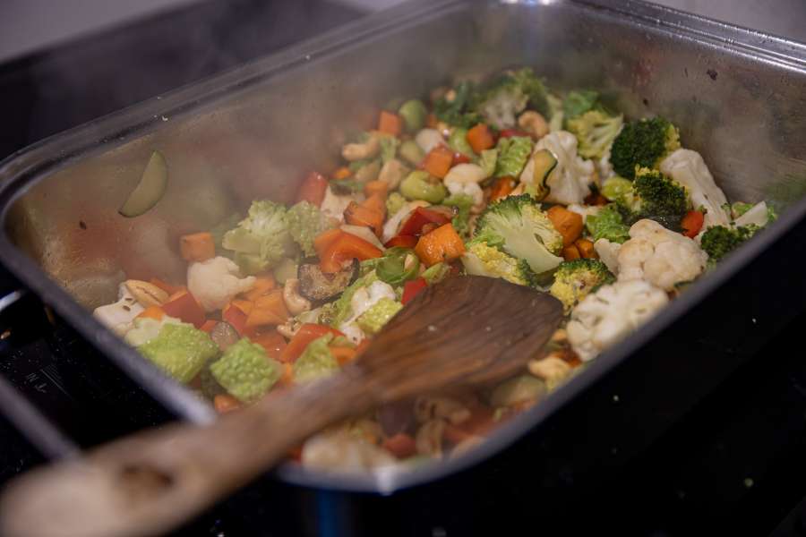 Das Thai Curry wird zusammen mit dem Gemüse in der großen Pfanne bzw. Bräter scharf angebraten und mit der Curry Kokosmilch Masse abgelöscht.